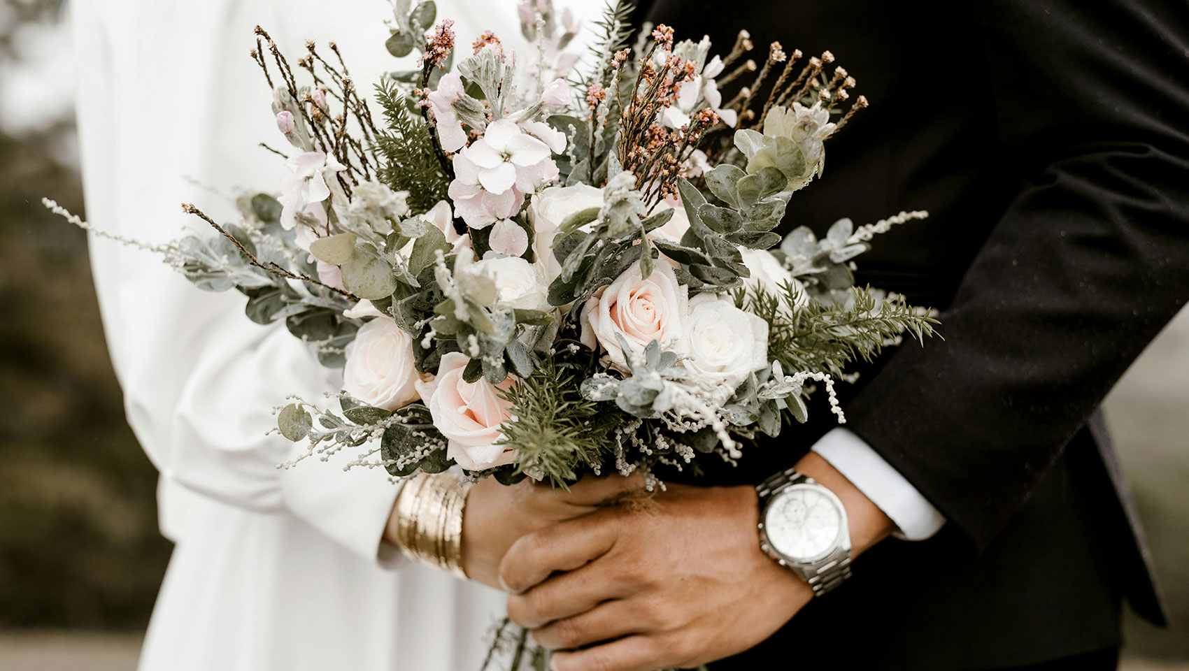 bride and groom holding a bouquet of flowers